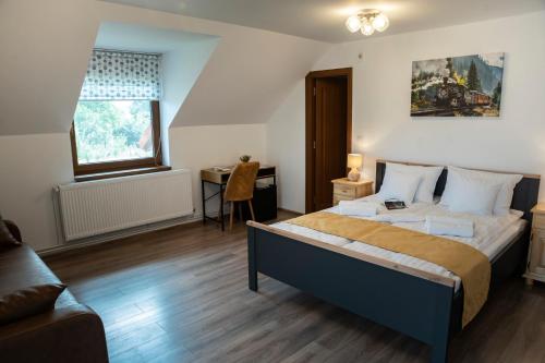 克尔茨什瓦拉乡Magda Garden的一间卧室配有一张床、一张桌子和一张沙发