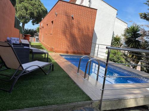 布拉内斯Villa for 2 families的庭院内的游泳池,配有长凳和椅子