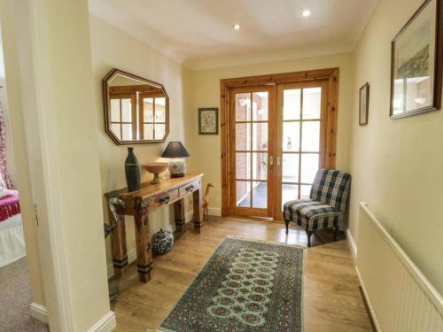 凯尔索Abbeyside Cottage的一间设有镜子、椅子和桌子的房间