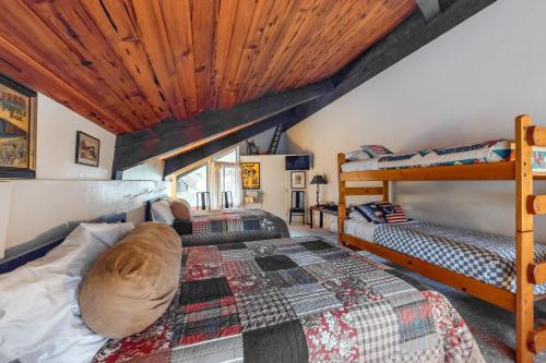 斜坡村Station Fairway One的一间卧室设有两张双层床和木制天花板。