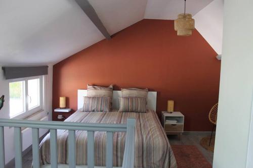 萨尔特河畔弗莱斯涅Maison rénovée Atoué loc的一间卧室配有一张橙色墙壁的床