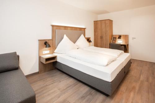 菲尔斯比堡Landgasthof Maier的一间卧室配有一张大床和一张沙发