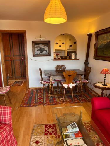 克莱恩 蒙塔纳La casetta di Crans的客厅配有桌子和红色沙发