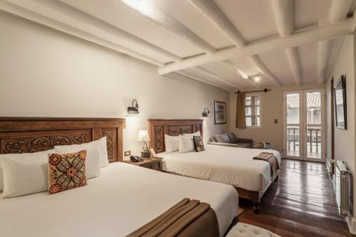 库斯科安提瓜卡索纳圣布拉斯酒店的酒店客房,设有两张床和一张沙发