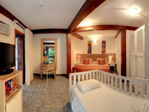 博拉塞亚萨尔维迪普拉亚酒店的一间卧室配有一张床、一台电视和一张床,另一间卧室配有