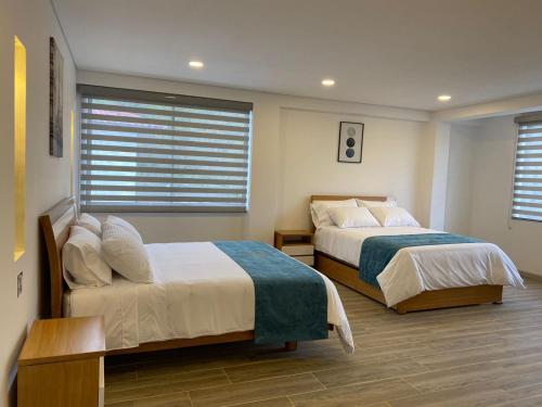 拉米萨HOTEL ISIS CONFORT的一间卧室设有两张床和窗户。