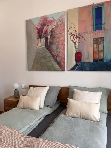 耶维克Apartamenty Rynek 18的一间卧室设有两张床,墙上挂着一幅画