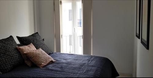 里斯本里斯本丁斯酒店的卧室配有带枕头的床铺和窗户。