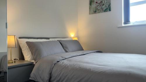 西布罗姆维奇Luxury apartment in dudley的卧室配有白色的床和窗户