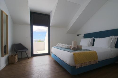 蓬塔德尔加达Pêro Teive Bay Apartments Hotel的一间卧室设有一张大床和一个大窗户
