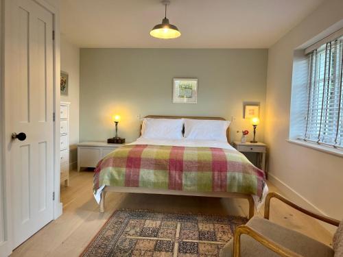 莱姆里吉斯Cobblers Lodge的一间卧室配有一张带铺着平底毯的床