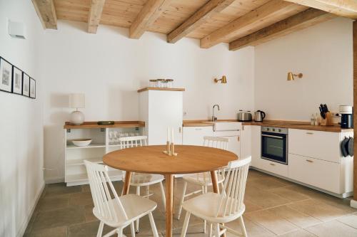 BarkelsbySchmiede的厨房配有木桌和白色椅子
