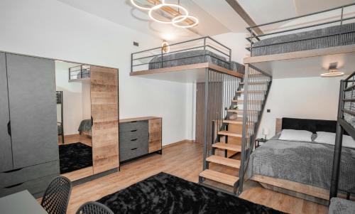 特鲁特诺夫Apartmánový dům Sklípek的一间卧室设有双层床和楼梯。