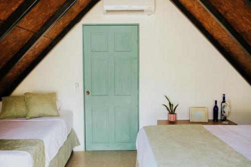 EscuintlaLos Olivos La Playa Hotel y Restaurante的阁楼卧室设有两张床和一扇蓝色的门