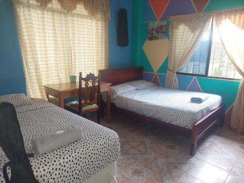 巴克里索莫雷诺港C.C. Habitaciones的客房设有两张床、一张桌子和一张书桌。