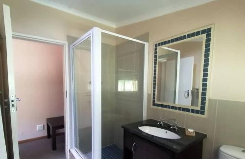 姆巴巴内Redberry Guest House的一间带水槽和镜子的浴室