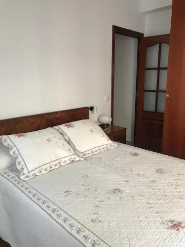 拉科鲁尼亚Piso Cuatro Caminos的一间卧室配有一张大床和木制床头板