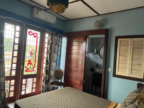 科托努La Villa Saint Jean的一间卧室设有一张床、一个窗口和一间浴室