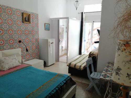 拉马萨The 18, Marsa Guest House的一间卧室配有一张床、一张桌子和一个窗户。