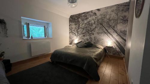 Belmont-sur-ButtantGîte Chantoiseaux的一间卧室配有一张床,墙上挂着树壁画