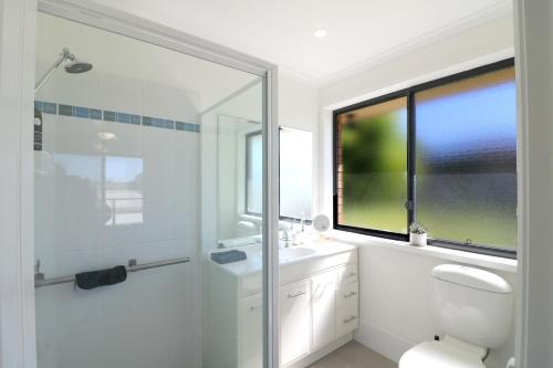 Tura BeachThe Views - 3 or 4 Bedroom的带淋浴和卫生间的浴室以及窗户。