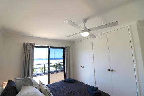 Tura BeachThe Views - 3 or 4 Bedroom的一间卧室配有吊扇、一张床和一个窗户。