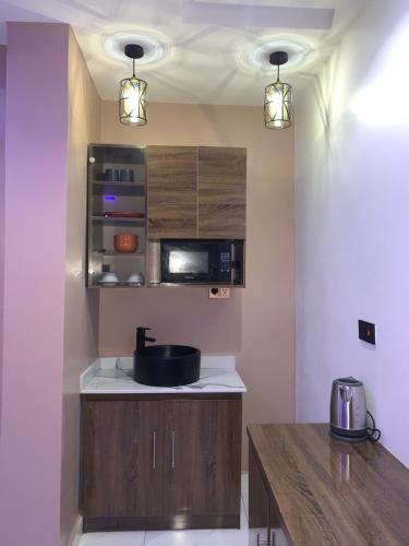 阿布贾Executive Royal Suite Kado的厨房配有水槽和微波炉