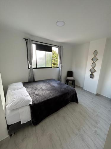 麦德林Medellin, elegante y central apartamento的一间卧室设有一张大床和一个窗户。