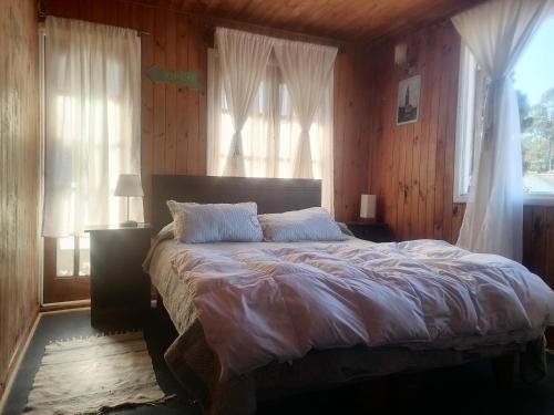埃尔基斯科Habitación Oda al Amor de la Estancia的一间带一张大床的卧室,位于带木墙的房间