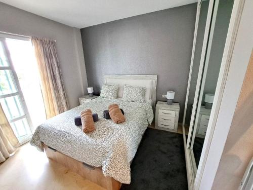 马拉加BEAUTIFUL 2 BED APARTMENT WITH POOL AND GOLF VIEWS的一间卧室配有一张带两条棕色毛巾的床