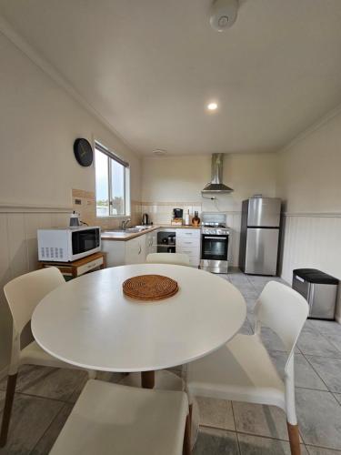 雅纳基普罗姆盖特逍遥度假屋的厨房配有白色的桌子和白色的椅子