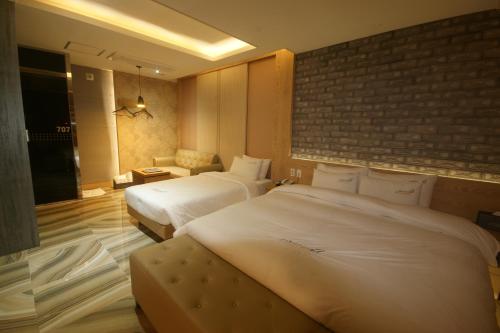 釜山机场酒店的酒店客房带两张床和砖墙