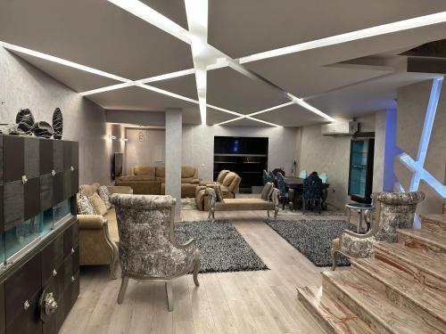 Sheikh ZayedTrio villa with falls in compound فلا بحديقة كبيره وشلالات صناعية的客厅配有沙发、椅子和电视