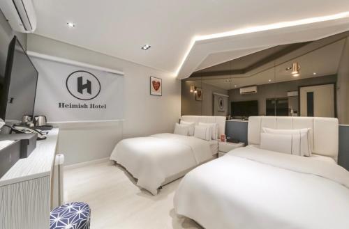 统营市Heimish Hotel的一间酒店客房,房间内设有两张床