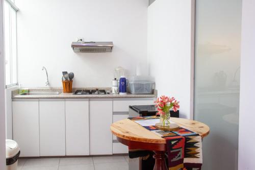 阿亚库乔Apartamento Altoandino的厨房配有一张桌子,上面放着花瓶