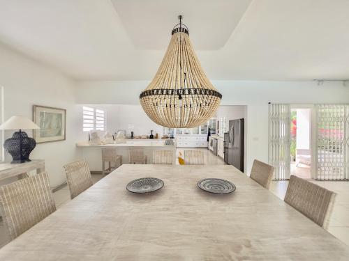 康隆尼角Villa White Horizon by Sealodge的大型用餐室配有桌椅和吊灯