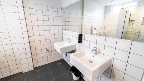 曼谷PIER 808 Hostel的白色瓷砖浴室设有两个盥洗盆和镜子