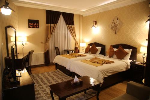 Gholghola Hotel by the Buddhas of Bamyan的酒店客房设有一张大床和一张桌子。