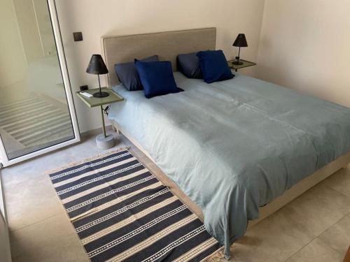雅典Maison centre Athènes的一间卧室配有一张带蓝色枕头的大床