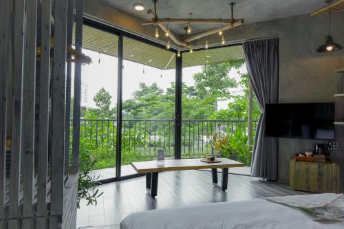 头顿Babylon Mini Resort的一间卧室配有一张床铺和一张桌子,并设有一个阳台