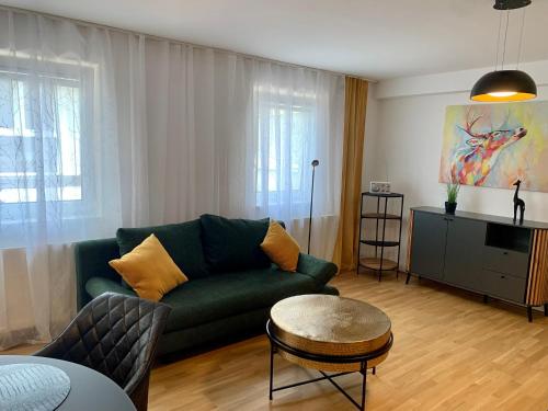 圣珀尔滕Ruhiges Apartment mit Terrasse im Zentrum St. Pölten的客厅配有绿色沙发和桌子