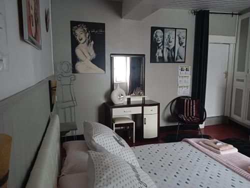 布里阿尔Marie-Claire la grillade的一间卧室配有一张床、一张书桌和一面镜子
