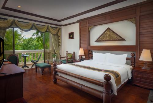 暹粒THE PRIVILEGE FLOOR by Borei Angkor的一间卧室设有一张床和一个大窗户