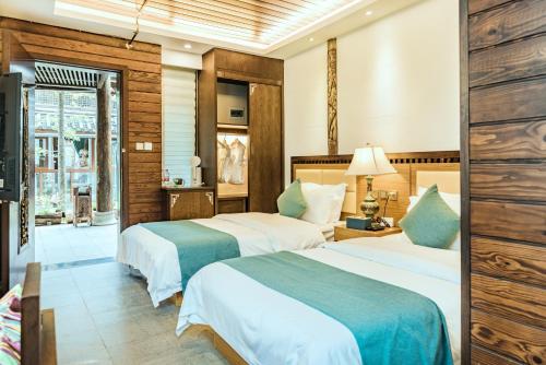 丽江丽江束河元年别院 Yuannian Lijiang的酒店客房设有两张床和窗户。