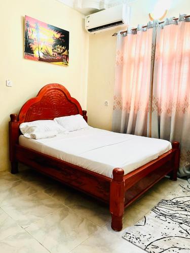 MaziziniNakupenda的一间卧室配有一张红色床头板的床