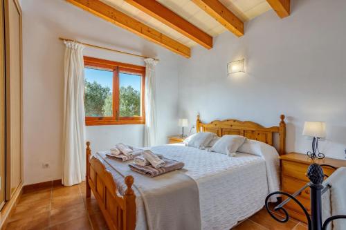 卡拉桑塔尼Chalet Turó的一间卧室配有一张带白色床单的床和一扇窗户。