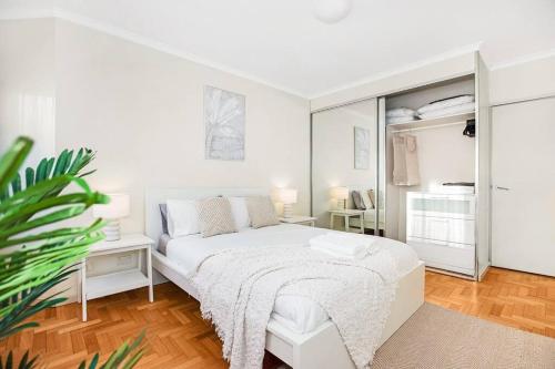 悉尼Perfect Manly Retreat.的白色卧室配有白色的床和植物