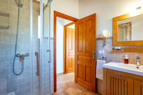 卡拉桑塔尼Chalet Turó的带淋浴、盥洗盆和镜子的浴室