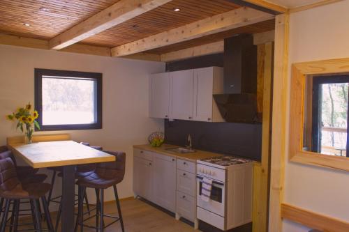 佩鲁斯基SOUL RETREAT BEACH HOUSE的厨房配有白色橱柜、桌子和柜台。