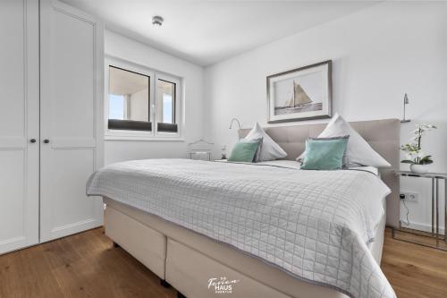 奥尔本尼兹Segler Nest的白色卧室配有一张带绿色枕头的大床
